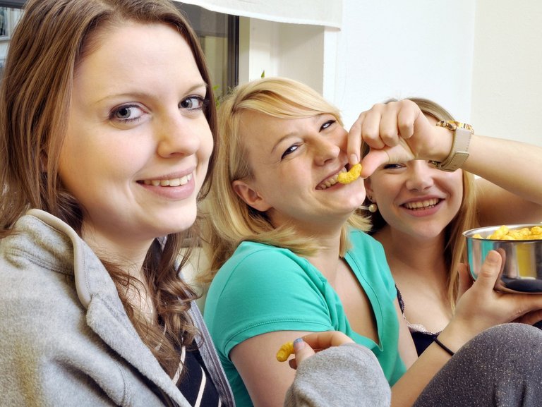 Drei junge Frauen beim gemeinsamen Erduss-Flipps-Essen haben Spaß