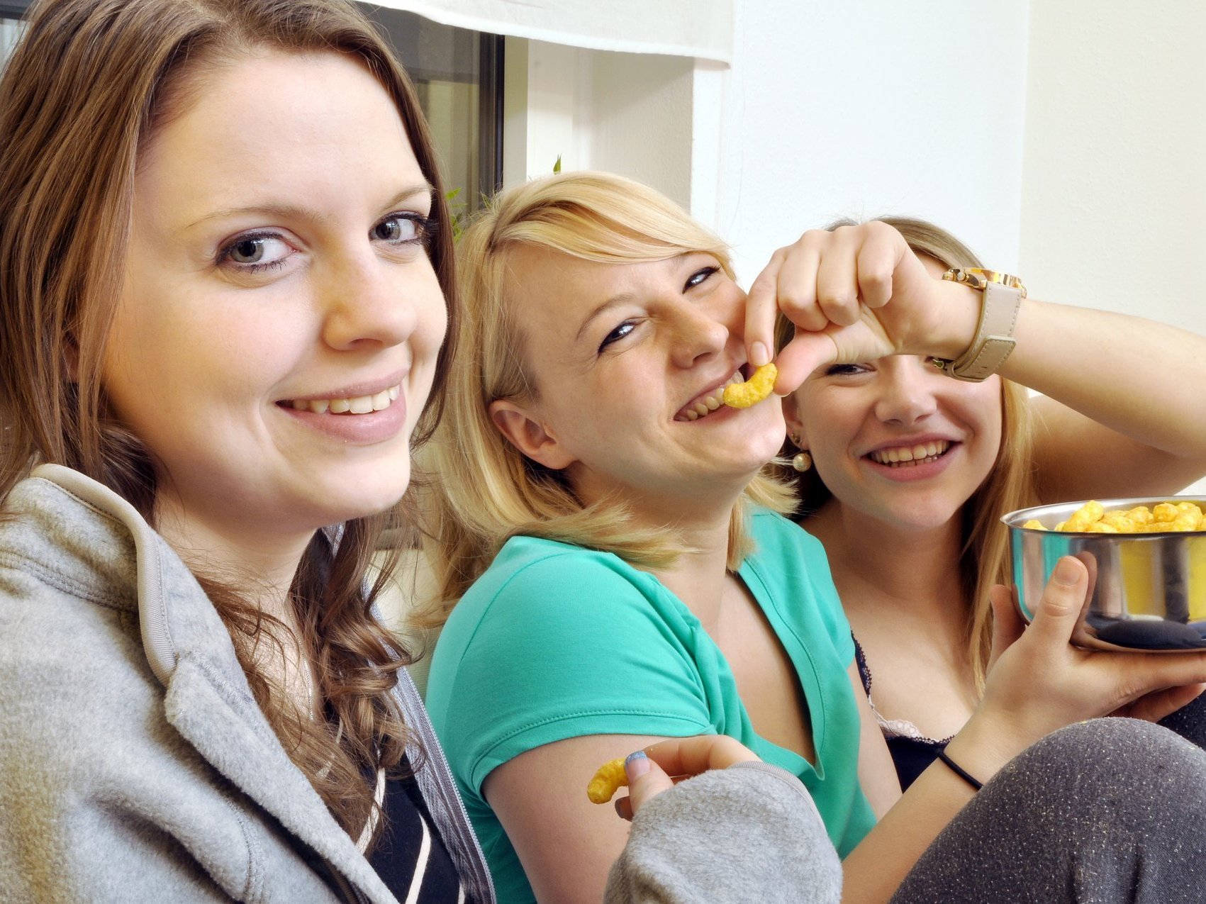 Drei junge Frauen beim gemeinsamen Erduss-Flipps-Essen haben Spaß