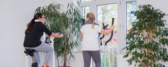 Frauen am Indoor-Fahrrad und Crosstrainer